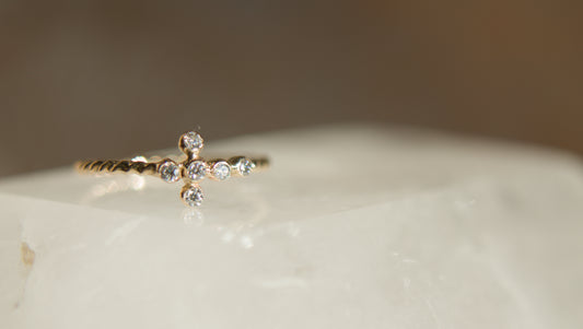 Gold ring with diamonds on a white stone surface